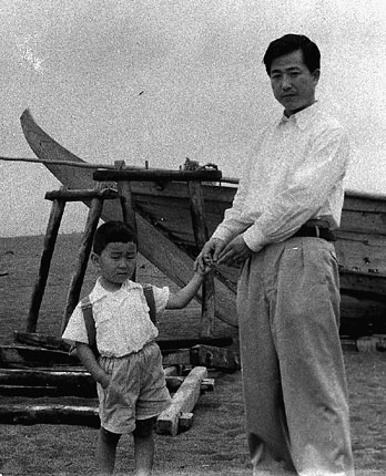 I am with my father, fishing boat behind us.